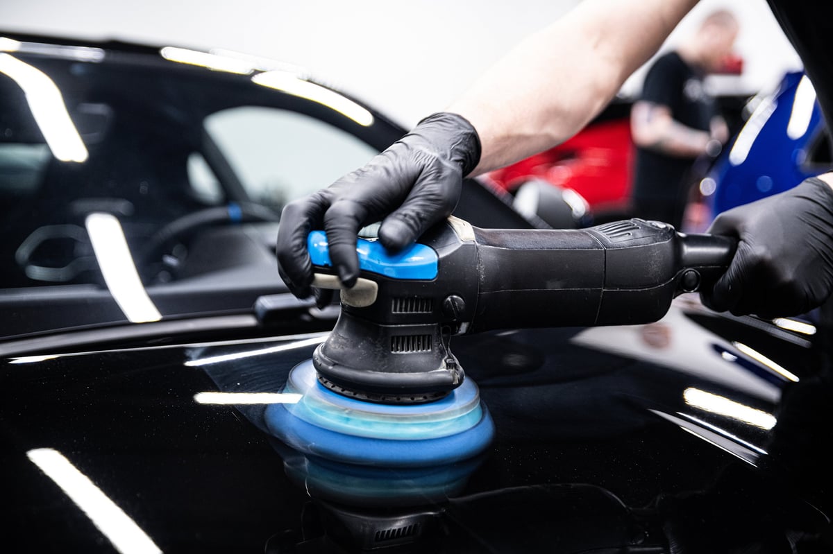 Professional machine polishing a glossy vehicle finish during paint correction and ceramic coating